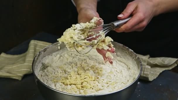 Slow motion closeup female hands clean metal whisk from leftovers of soft dough — Stock Video