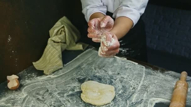 Slow motion of woman holds white flour in hands ready to sprinkle on piece of dough — Stock Video