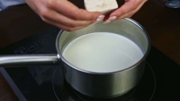 Slow motion closeup on woman hands ready to crush dry yeast into boiled milk — Stock Video