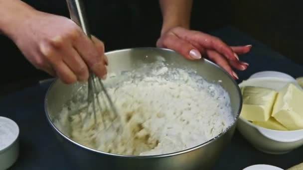 Lenti primo piano mani femminili mescolando con frusta farina bianca con pasta morbida — Video Stock