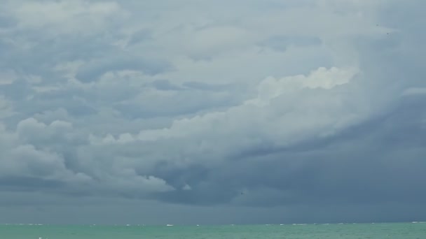 Büyük gri bulutlar üzerinde hızlı bir panorama. Mavi okyanusun üzerindeki fırtınalı karanlık gökyüzünde süzülür. — Stok video