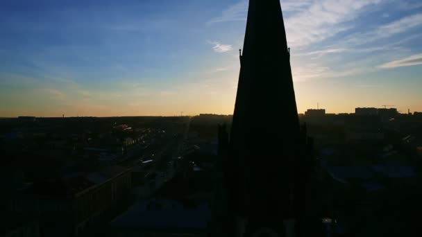 Vita moln flyter sakta ovanför ljus sol och gamla stan siluett vid solnedgången — Stockvideo