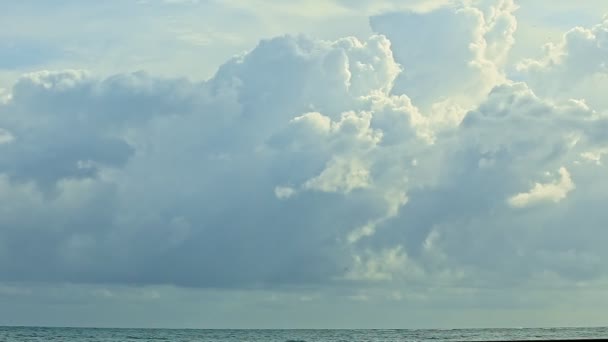 Langzaam panorama rechts op grote pluizige witte wolken zweven boven eindeloze blauwe zee — Stockvideo