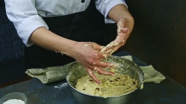 Женщина в замедленной съемке очищает руки от мягких остатков теста над металлической миской — стоковое видео