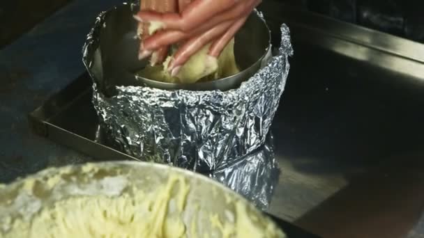 Detailní žena ruce pomalu dát část měkkého kvasinkového těsta do velké formy pečení — Stock video
