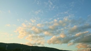 Gün batımı gökyüzünde yavaşça kalan manzara alçak dağların tepesinde kabarık bulutlar