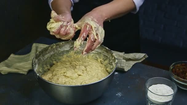 Detailní žena pomalu čistí ruce od měkkých zbytků těsta nad kovovou miskou — Stock video