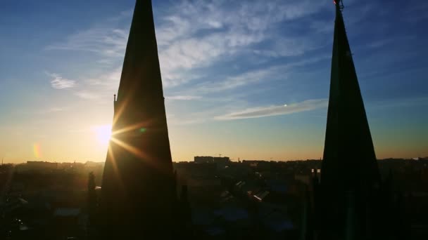 Sarı güneş, yüksek kilisenin siyah siluetlerinin arkasına saklanıyor. Mavi gökyüzüne karşı yükseliyor. — Stok video