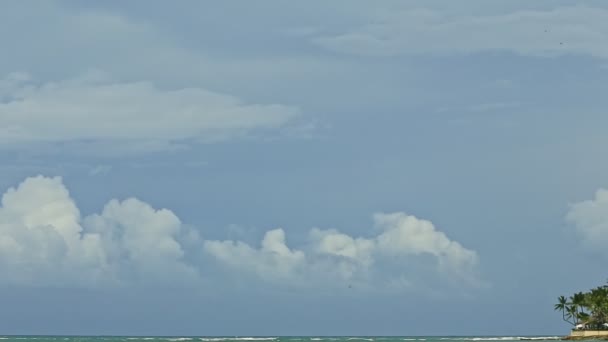 Αργά πανόραμα σε μεγάλα χνουδωτά άσπρα σύννεφα επιπλέουν στον γαλάζιο ουρανό πάνω από τον απέραντο ωκεανό — Αρχείο Βίντεο