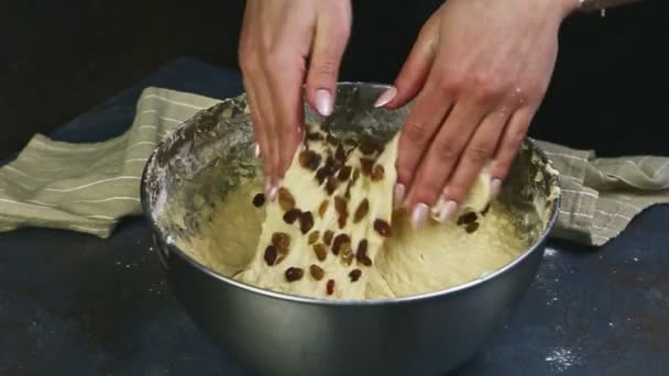 Pomalý pohyb detailní žena ruce hnětení měkké těsto s rozinkami v kovové míse — Stock video