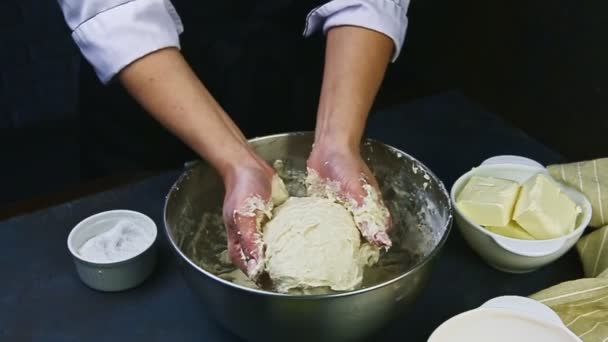 Zpomaluje pohyb cukráře rukama hnětá měkké kvasinkové těsto v hluboké kovové míse — Stock video