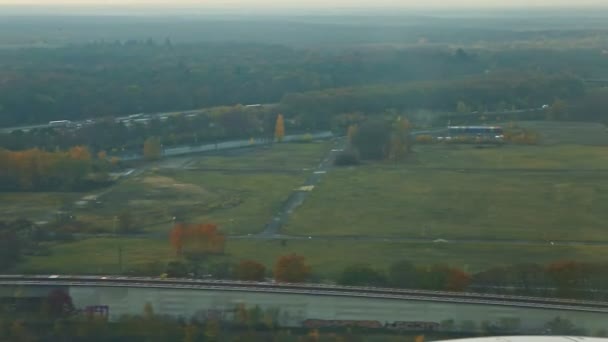 Vue aérienne depuis la fenêtre de l'avion sur les champs verts et la forêt d'automne — Video