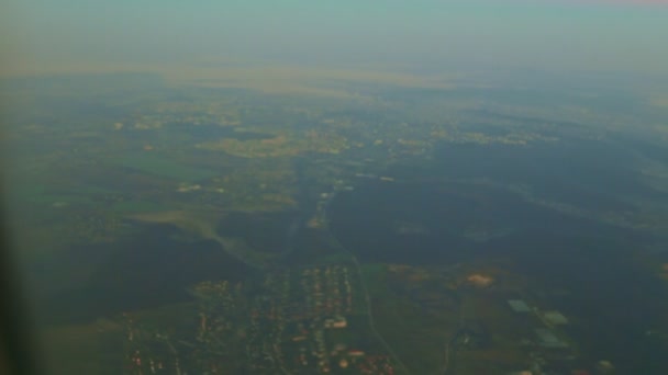 Soft focus vue aérienne depuis la fenêtre de l'avion sur un terrain vert au lever du soleil — Video