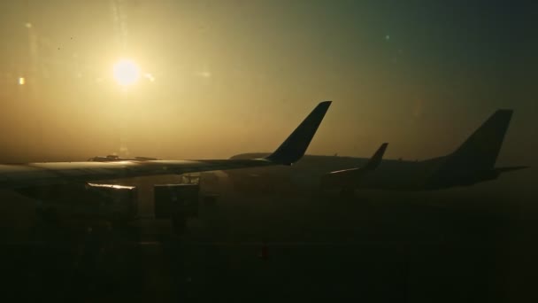 Kilátás ablakból repülőgép szárnyak ellen fényes nap keresztül köd napkeltekor — Stock videók