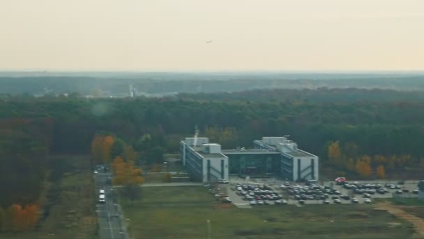 Vista aérea desde el avión de la ventana vuela rápidamente por encima de los campos verdes y el bosque de otoño — Vídeo de stock