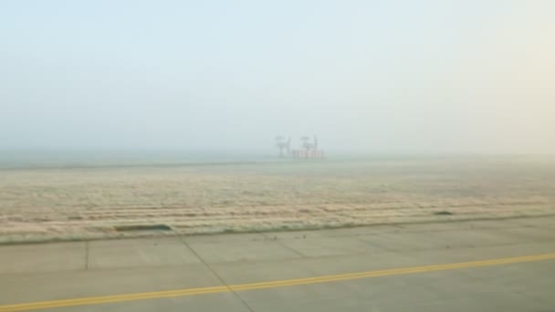 Панорамний вид з вікна літак їде на порожній злітно-посадковій смузі проти полів в тумані — стокове відео
