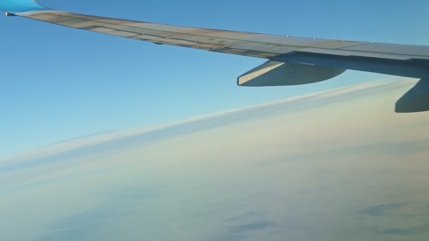 Vista aérea da janela da aeronave em grande asa de aço voar acima de nuvens brancas — Vídeo de Stock