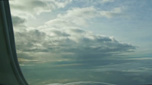 Luchtfoto vanuit vliegtuigraam op witte pluizige wolken vliegen boven stalen straalmotor — Stockvideo