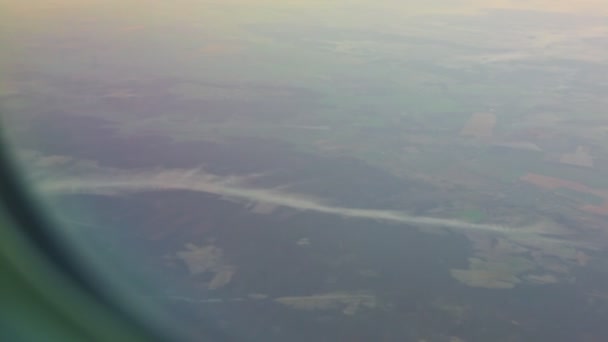 Soft focus vue aérienne depuis la fenêtre de l'avion sur terre verte et nuages blancs — Video