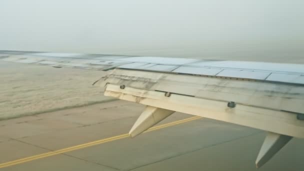 Luftaufnahme aus dem Flugzeugfenster auf Stahl fliegt über die leere Landebahn des Flughafens — Stockvideo