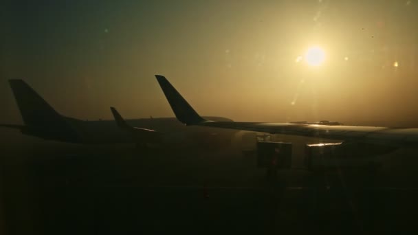Közeli kilátás repülőgép szárnyak repülőgép ablakán keresztül köd napkeltekor — Stock videók