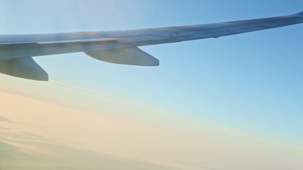 Luftaufnahme aus dem Fenster auf Flugzeugflügel fliegen über niedrige Berge mit weißem Nebel — Stockvideo