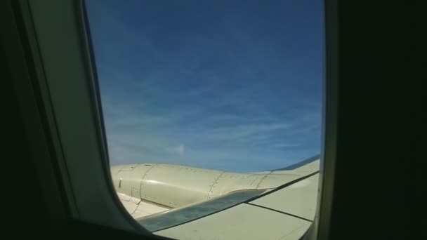 Widok z lotu ptaka z okna samolotu na puszyste białe chmury latać nad dużym silnikiem odrzutowym — Wideo stockowe