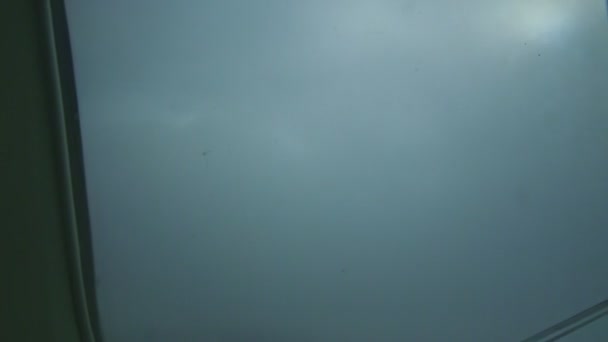 在灰色云彩的飞机窗上俯瞰高空，在大型喷气式发动机上方飞行 — 图库视频影像