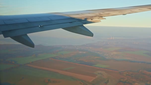 Vista aerea da finestra su ala d'acciaio volare basso sopra terra verde con nebbia bianca — Video Stock