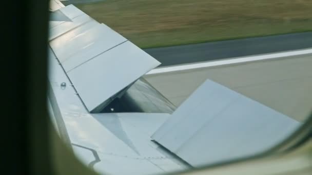 Widok z bliska z okna samolotu na otwartym skrzydle stalowym porusza się pustym pasem startowym — Wideo stockowe