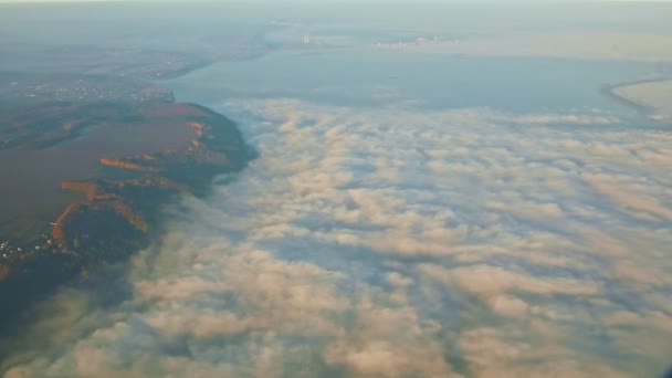 Vue aérienne depuis la fenêtre de l'avion sur les montagnes et la large rivière avec des nuages blancs — Video