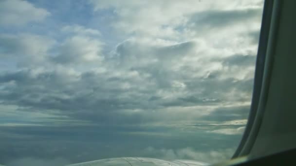 Vue aérienne depuis la fenêtre de l'avion sur un gros réacteur volant au-dessus du sol avec des nuages — Video