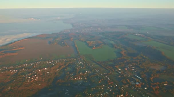 Vue aérienne depuis la fenêtre de l'avion sur la terre verte et les montagnes avec des nuages — Video