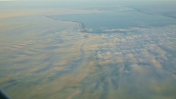 Вид з повітря з вікна літак літати над широкою річкою з білими пухнастими хмарами — стокове відео