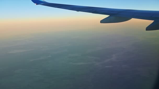 Widok z lotu ptaka z okna na skrzydło samolotu latać nad niskimi górami z białą mgłą — Wideo stockowe