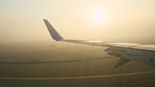 Panorámás kilátás a repülőgép ablakából acélszárny mozog üres kifutópályán — Stock videók