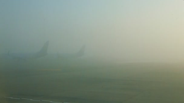 Panorámás kilátás az ablakos repülőgépről üres kifutópályával a ködben lévő mezőkkel szemben — Stock videók