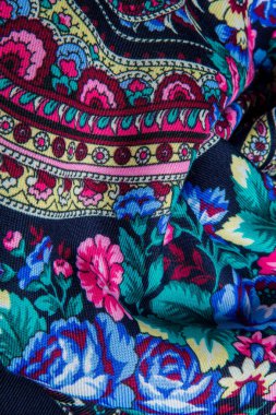 Üst manzara katlanmış koyu yumuşak pamuk eşarp parlak kırmızı, mavi ve yeşil çiçek desenli