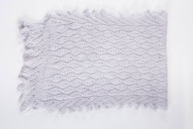 Üst görünüm düzlüğü, yarım el yapımı gri yünlü atkıyla beyaz arka planda eski Rus tarzında örülmüş.