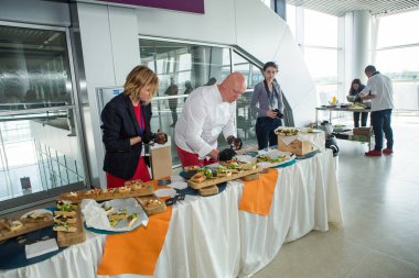 LVIV, UKRAINE - 24 Mayıs 2018: farklı üniformalı şefler 24 Mayıs 'ta Lviv havaalanı salonunda degulasyon için aperatifler servis masasında