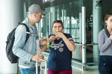 LVIV, UKRAINE - 24 Mayıs 2018: Birçok yolcu 24 Mayıs 'ta Lviv havaalanı salonundaki ücretsiz deguasyon masasından atıştırmalık ve içecek denedi