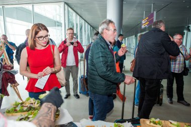 LVIV, UKRAINE - 24 Mayıs 2018: Birçok yolcu 24 Mayıs 'ta Lviv havaalanı salonundaki ücretsiz deguasyon masasından atıştırmalık ve içecek denedi