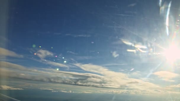 Воздушный вид из окна самолета на белые пушистые облака быстро летают на голубом небе — стоковое видео