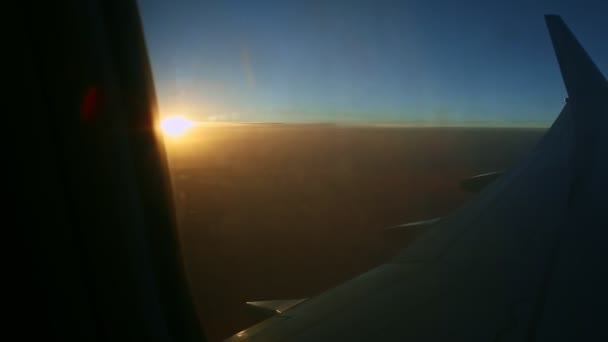 Aerial view from airplane window across steel wing silhouette at beautiful sunset — Stock Video