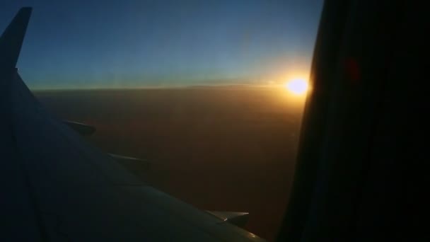 Вид з повітря з вікна літака через силует сталевого крила на літній захід сонця — стокове відео