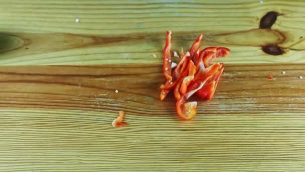 Top view on dark-skinned man by hands prepare to chop sliced red bell pepper — Stock Video