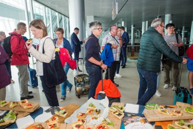 LVIV, UKRAINE - 24 Mayıs 2018: Birçok yolcu 24 Mayıs 'ta Lviv havaalanı salonundaki ücretsiz deguasyon masasından atıştırmalık ve içecek denedi