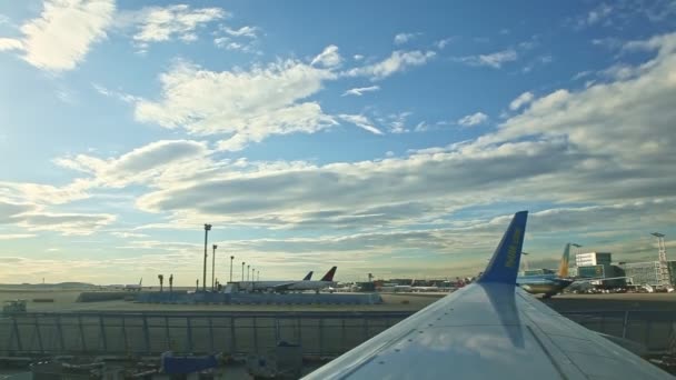 Vista generale da un finestrino di un aereo sulla pista di atterraggio con molti aerei — Video Stock