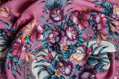 Üst taraf, parlak çiçekli, buruşuk pembe pamuklu atkıya yakın plan.