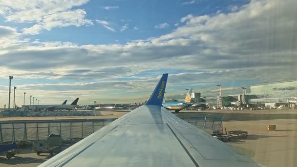 Vista general desde una ventana de avión en la pista de aterrizaje con muchas aeronaves — Vídeo de stock